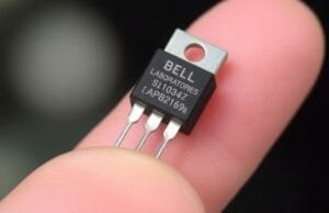 History of Processors: The Ultimate : Evolution Unveiled A close-up photograph of a vintage Bell Laboratories point-contact transistor, a significant milestone in the History of Processors, highlighting its small size compared to a human finger.