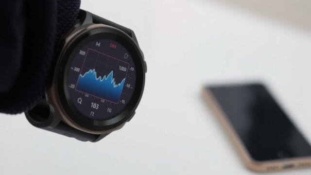 Apple wearable health and fitness: Apple Wearable Health &… A digital watch screen showing graph data, with a phone visible in the distance.