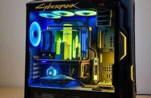 Game Themed PC Build: Crafting Your Ultimate Gaming Sanctuary A highly detailed, custom-painted PC case featuring elements from Cyberpunk 2077, with neon yellow and blue RGB lighting illuminating intricate miniature cityscapes inside.