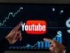 How to Earn Money on YouTube: Ultimate 2024 Guide A person confidently pointing towards a YouTube logo on a digital screen, surrounded by graphs and money symbols, representing growth and income.