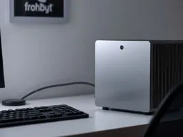 A sleek, modern Small Form Factor PC setup on a minimalist desk, showcasing its compact size next to a monitor and keyboard.
