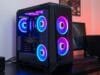 Building Your First PC: The Ultimate 2025 Guide A stylized, modern gaming PC build with RGB lighting on a desk, showcasing various components like the GPU and CPU cooler through a clear side panel. The desk also has a monitor, keyboard, and mouse.