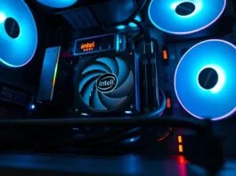 An eye-level shot of a sleek, modern PC build showcasing an Intel Core CPU cooler and an Intel Arc discrete GPU, illuminated by subtle RGB lighting. This serves as the featured image for an all-Intel PC.